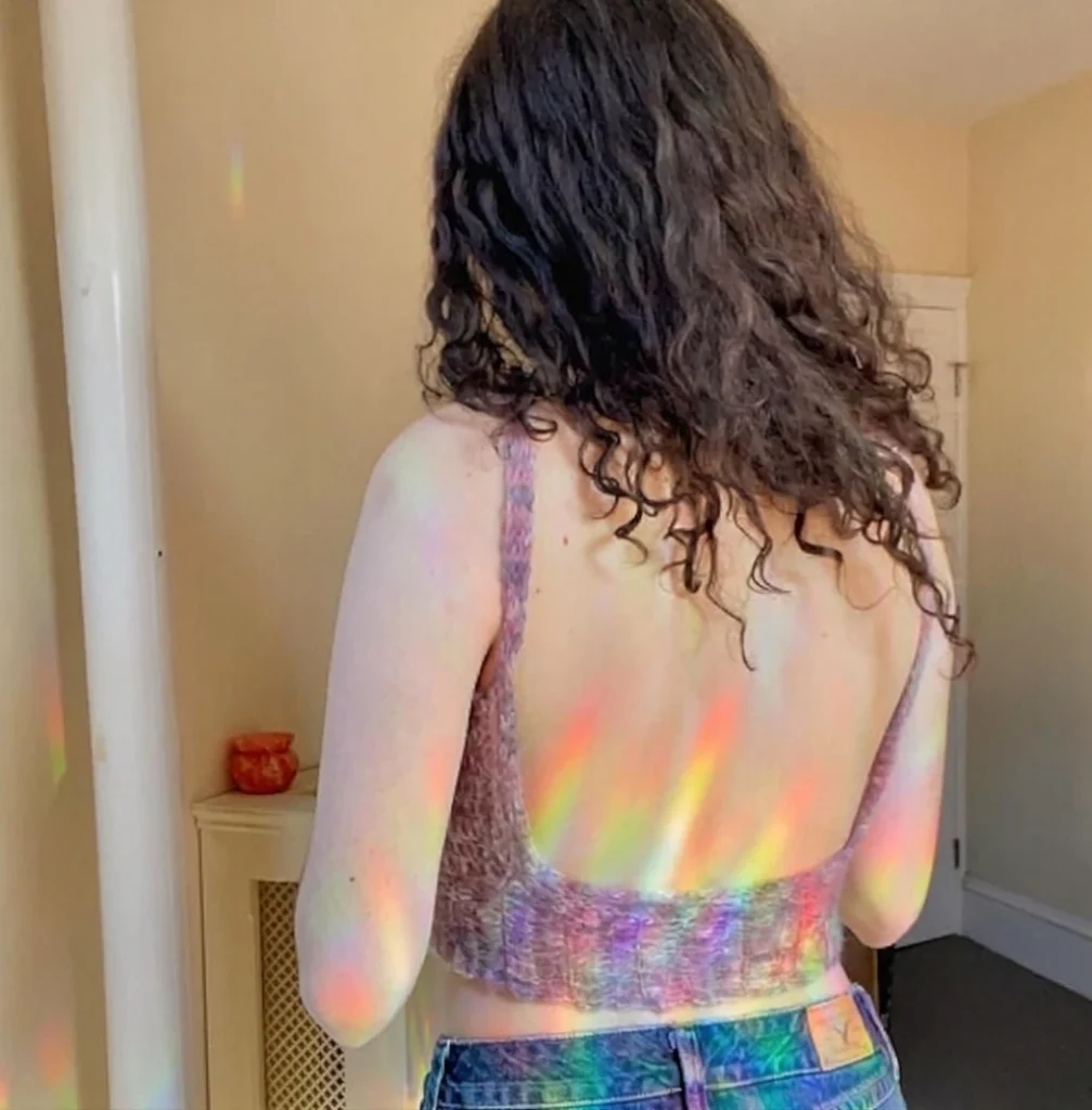 Back view of a model wearing a lilac crochet halter top with thin straps, photographed indoors